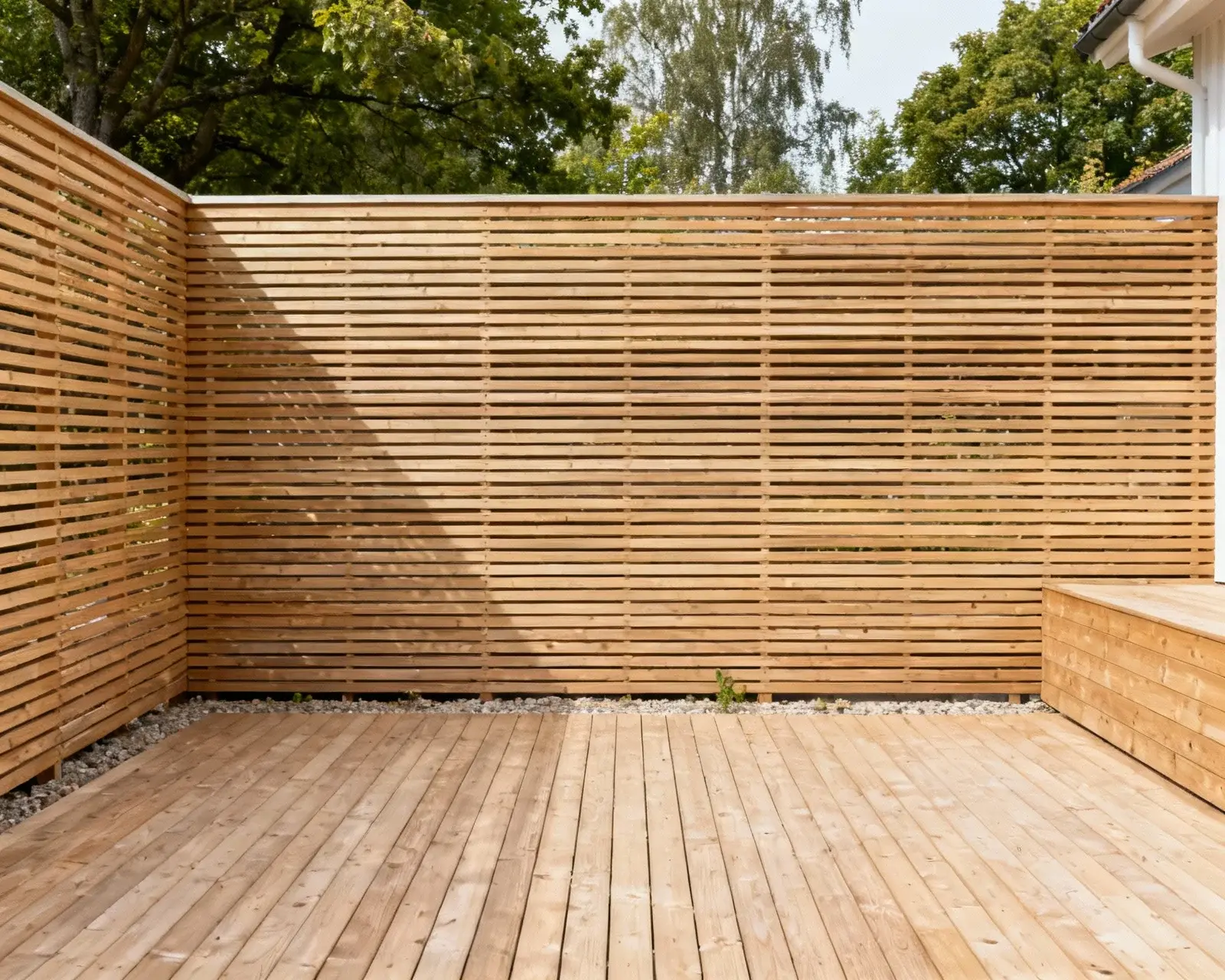 Modernt staket med liggande spjälor i svensk trädgård