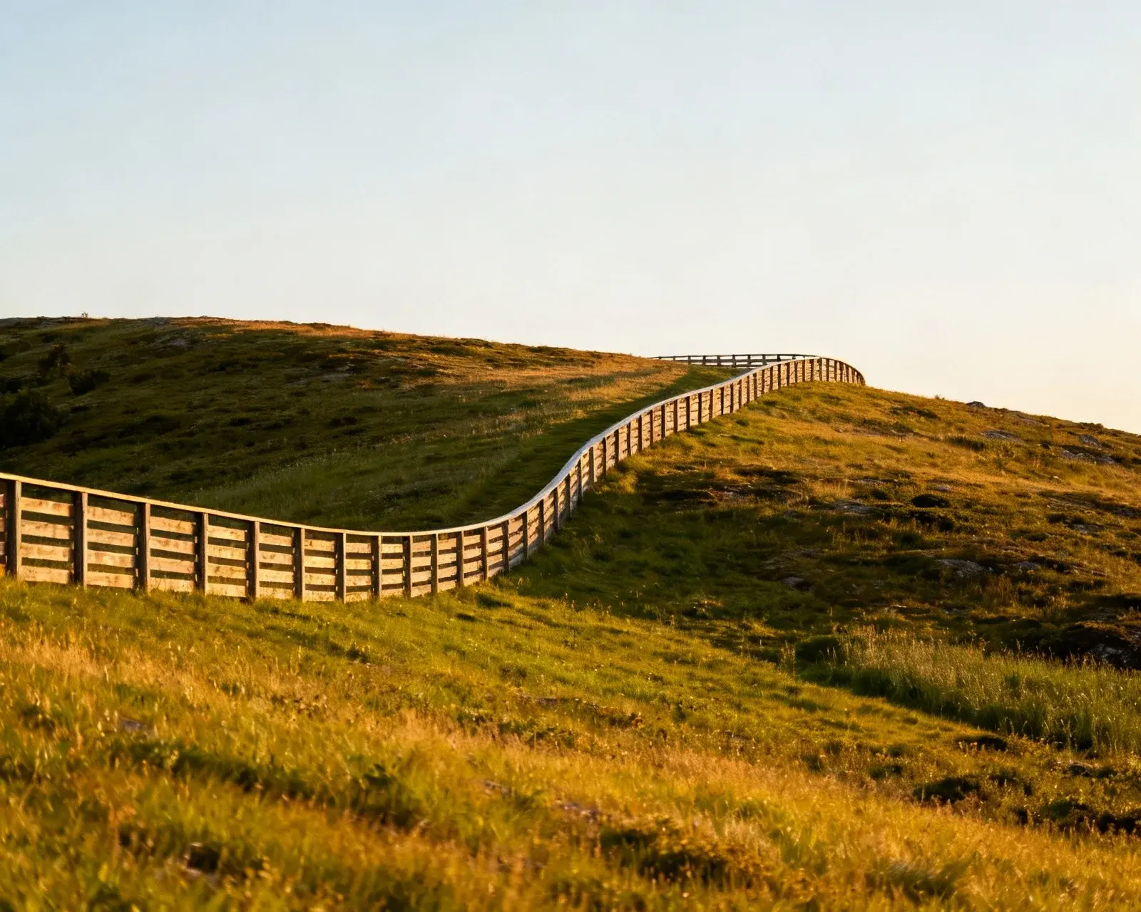 Staket som följer naturlig terrängkontur på svensk kulle