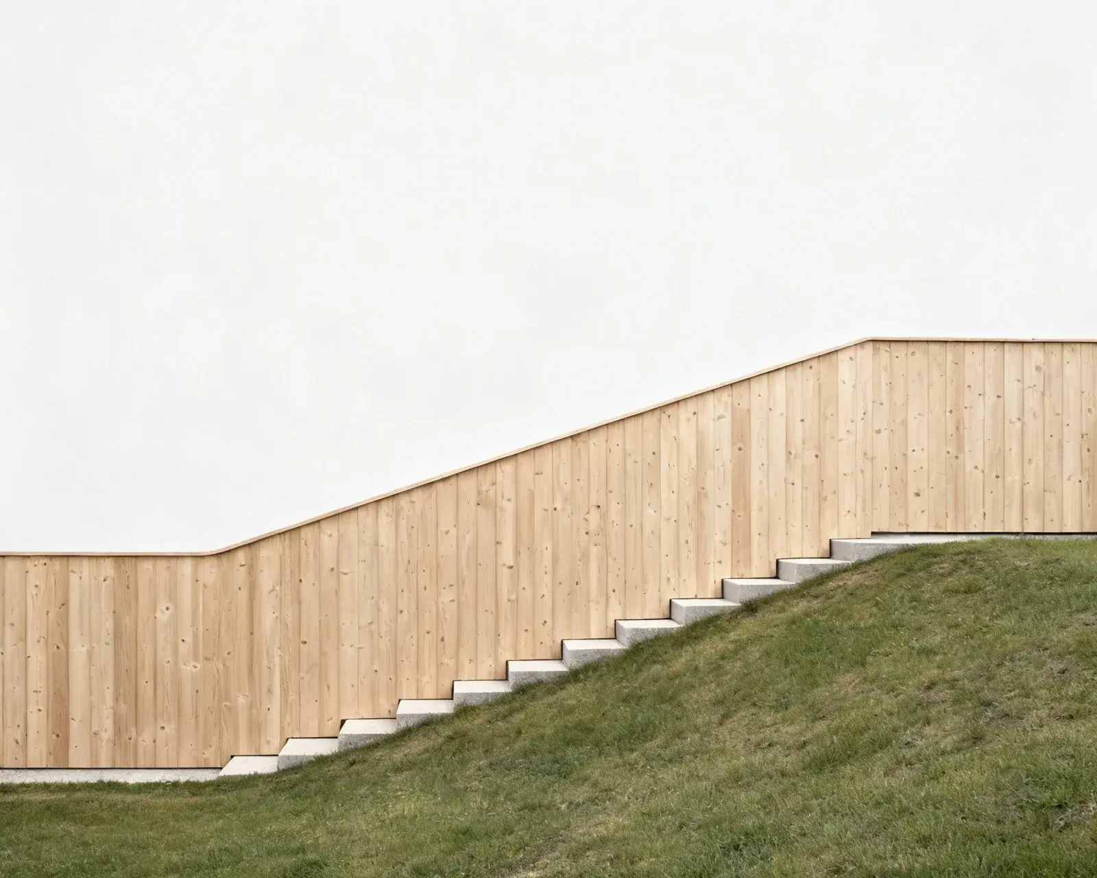 Staket som följer lutningen på sluttande tomt