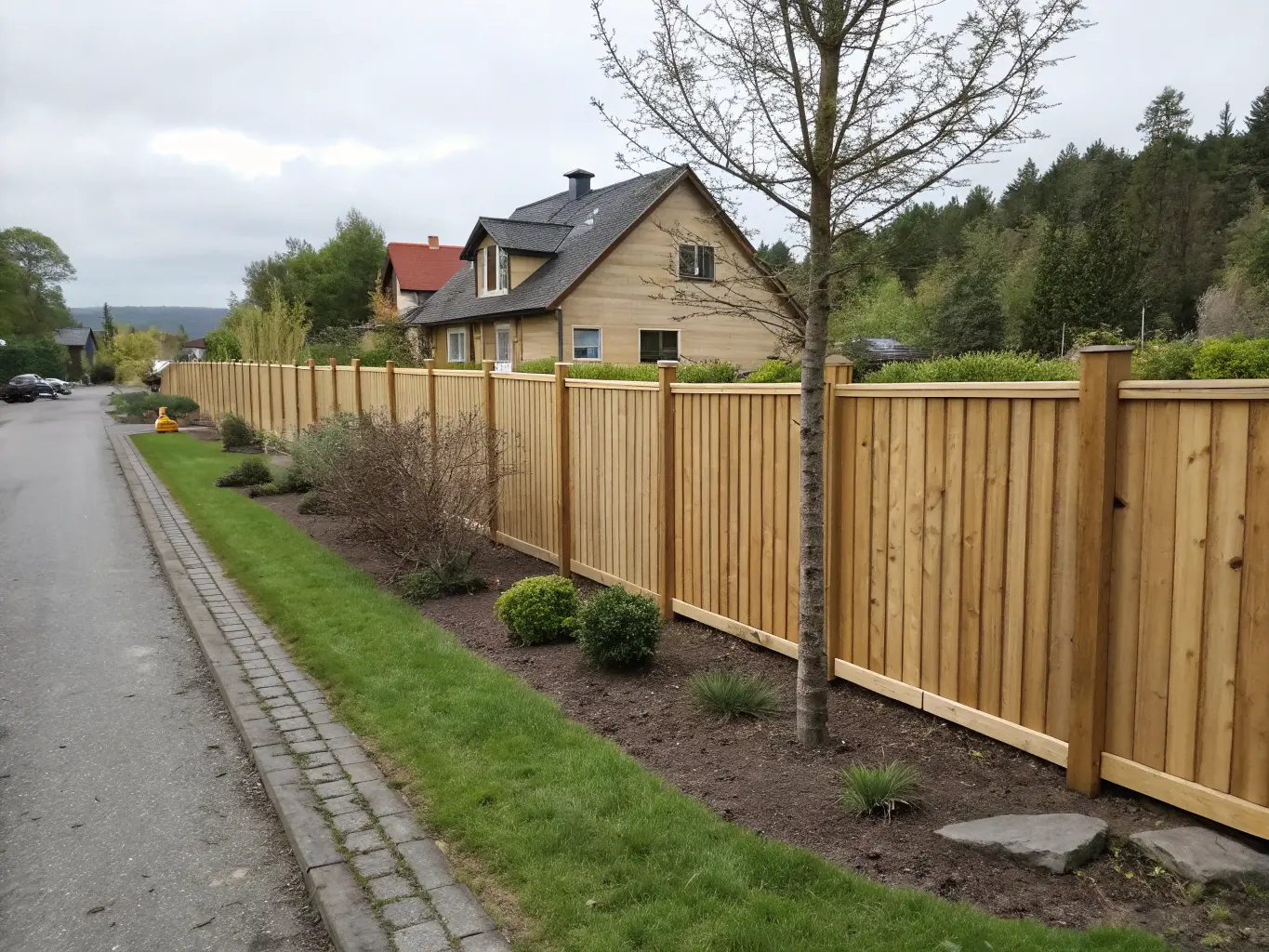 Högt plankstaket runt uteplats på egen tomt